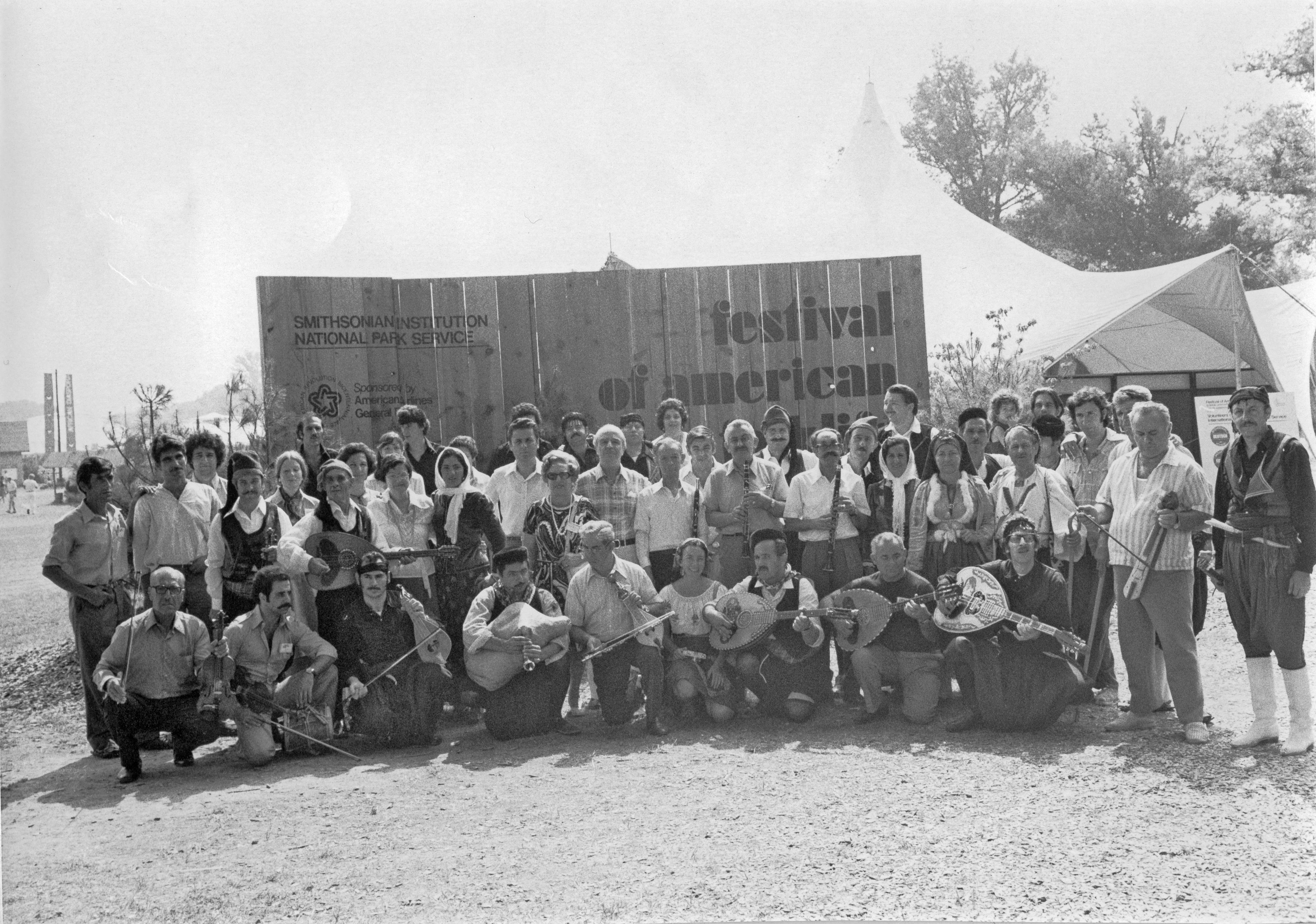 O Σωτήριος (Sam) Τσιάνης (κέντρο) με τον τότε Διευθυντή του Κέντρου Λαογραφίας Στέφανο Ήμελλο (νυν Επόπτη, Ακαδημαϊκό), τον αείμνηστο μουσικολόγο Σπυρίδωνα Περιστέρη και Έλληνες παραδοσιακούς μουσικούς και χορευτές στο Smithsonian Folklife Festival το 1976 κατά τις εορταστικές εκδηλώσεις για τα διακόσια χρόνια από την Αμερικανική Επανάσταση και την δημιουργία των Ηνωμένων Πολιτειών (Φωτογραφικό Αρχείο ΚΕΕΛ).